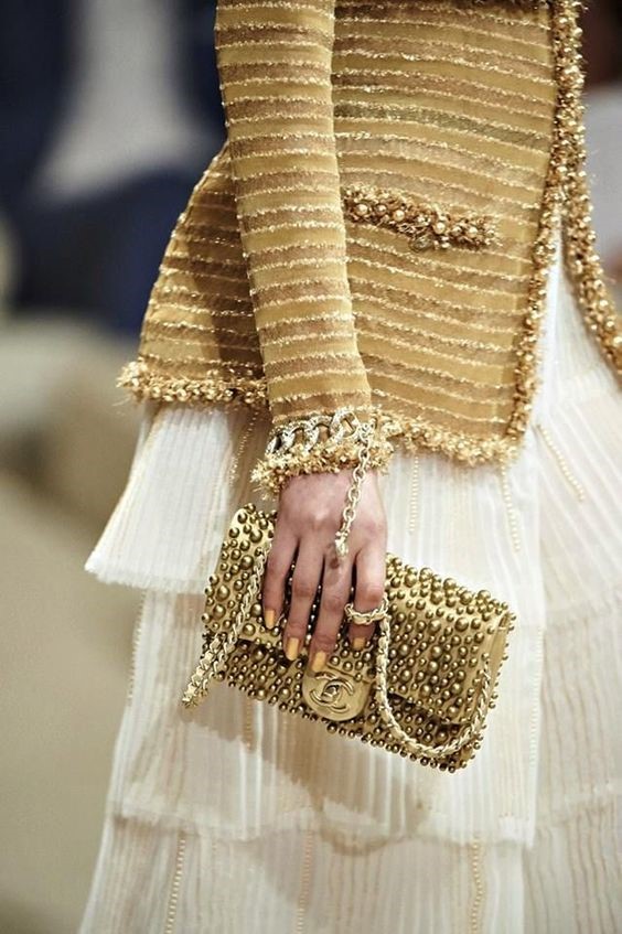 CHANEL COUTURE IN GOLD BLAZER AND GOLD BAG WITH A WHITE DRESS