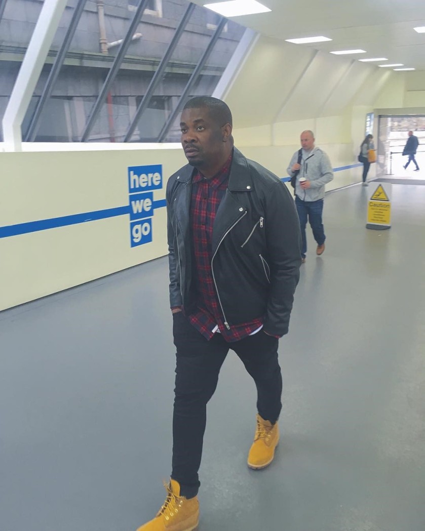 NIGERIAN MALE ARTIST DON JAZZY WALKING THROUGH AN AIRPORT PHOTO.png